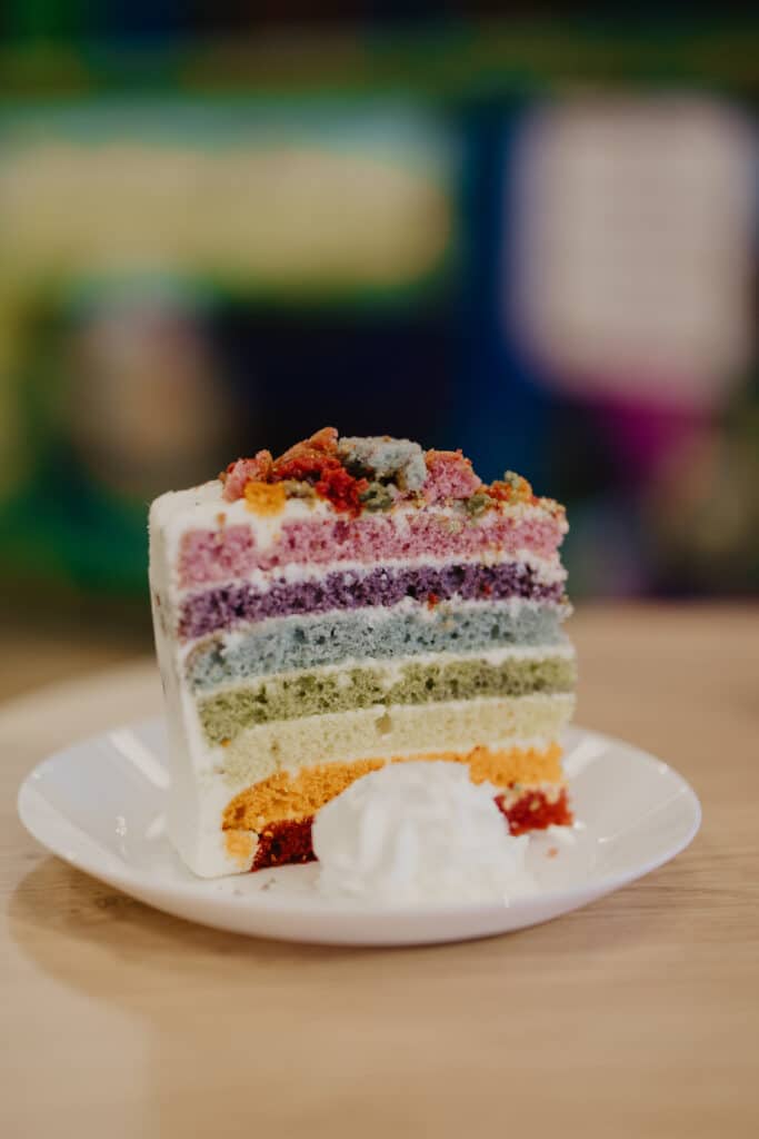 Slice of colourful layer cake served in the Tree House café