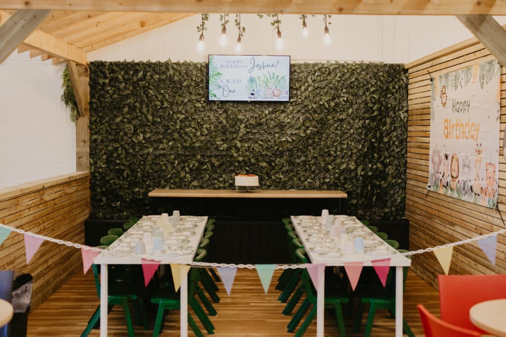 Decorated Tree House birthday party room with tables and bunting