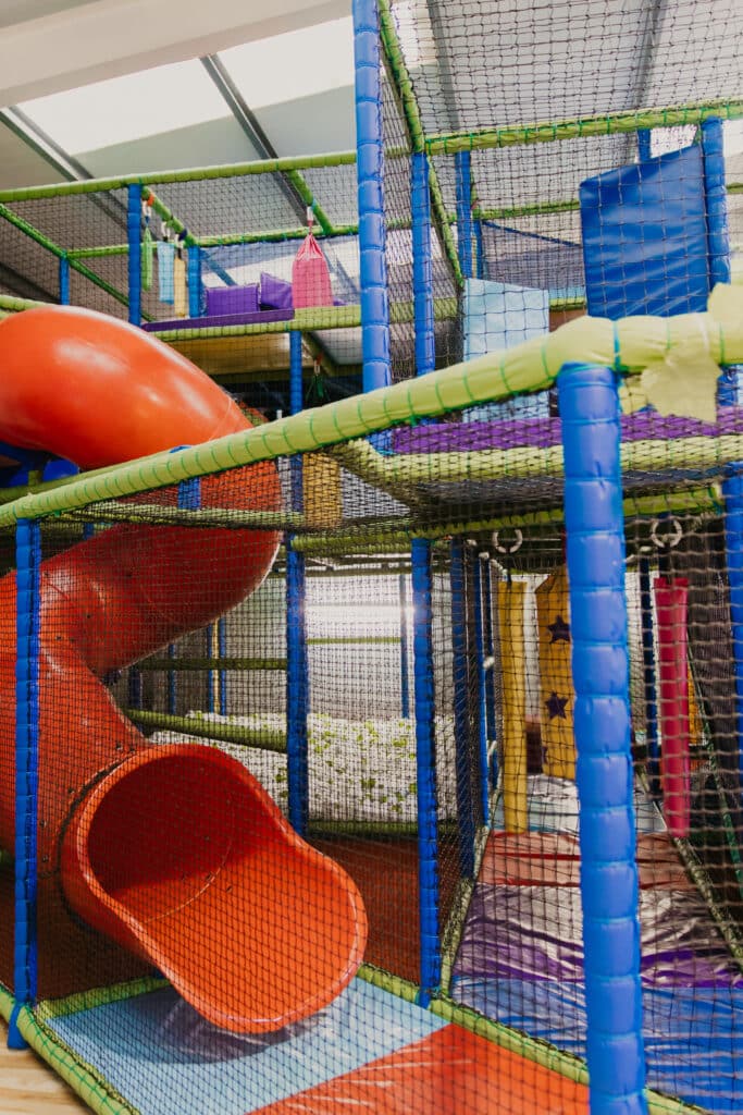 Red tube slide inside the Tree House soft play frame